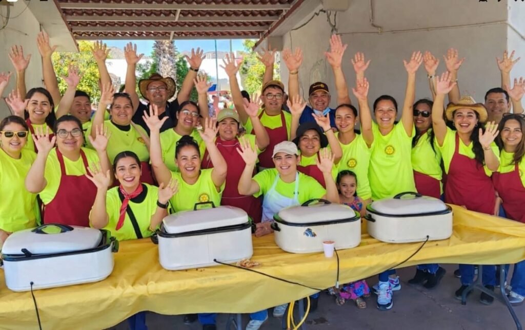 Group of Rotary Club San Carlos volunteers and community members raising their hands in celebration at a Club event